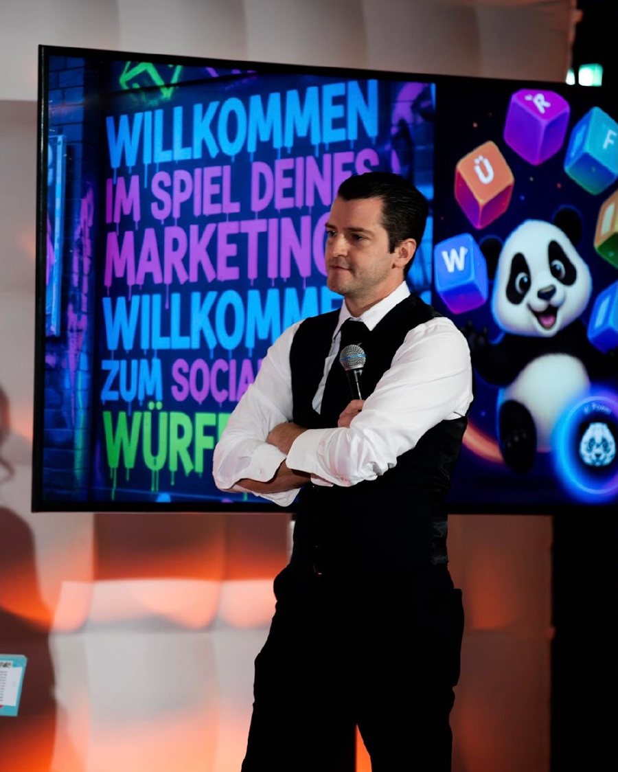 Roger Basler de Roca auf der Bühne vor einer KI-Präsentation
